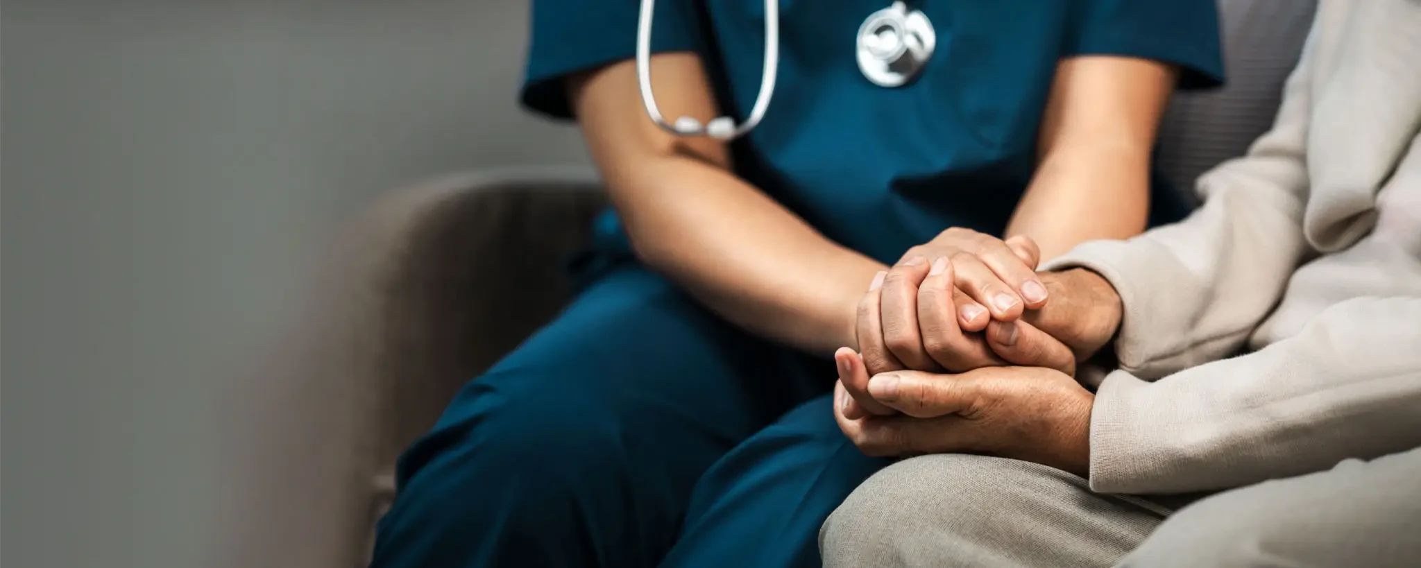 Nurse caregiver holding hands with patient