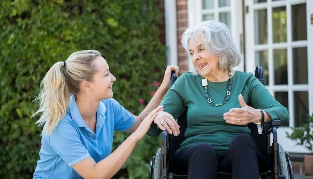 Care worker with resident outdoors